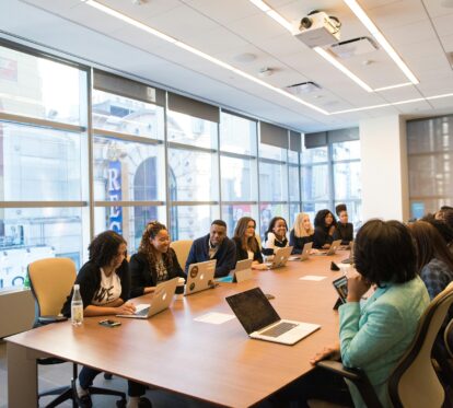 A diverse team of business professionals collaborating in a modern meeting room.